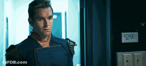 Man In Superhero Costume Looking In Hallway GIF