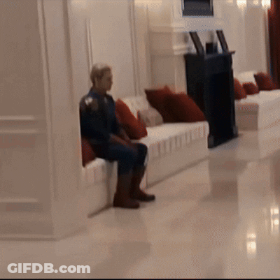 Man In Superhero Costume Sitting On Couch GIF