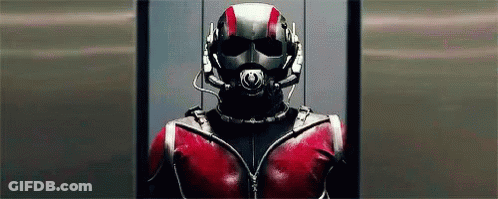 Man In Superhero Costume Standing In Elevator With Helmet GIF