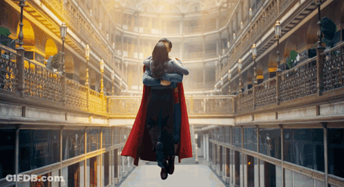 Man In Superman Cape Carrying Woman GIF