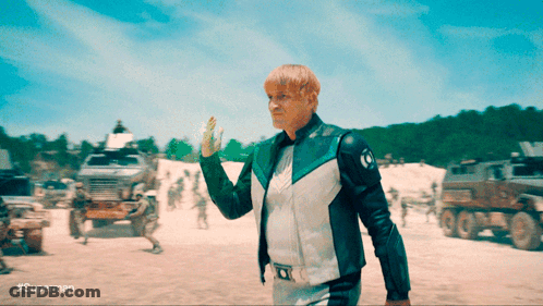 Man In Superman Costume Holding Green Object GIF