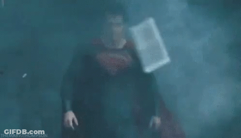Man In Superman Costume In Dark Foggy Room GIF
