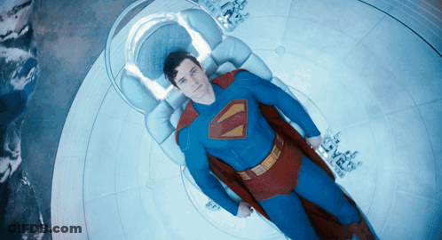 Man In Superman Costume Laying On Bed GIF