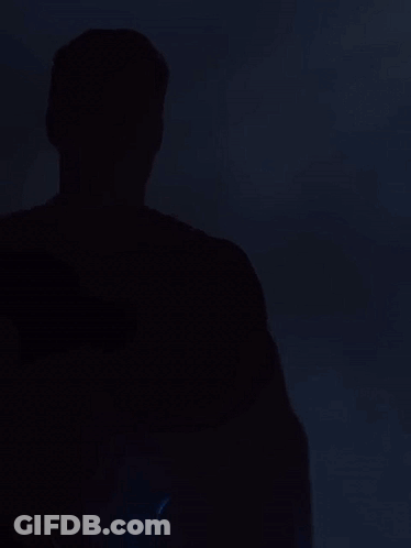 Man In Superman Costume Looking At Camera GIF