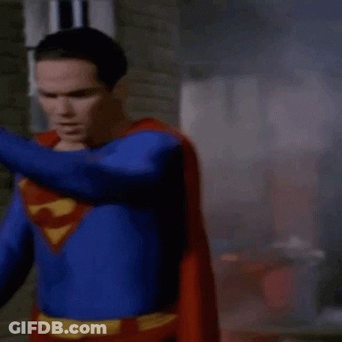 Man In Superman Costume Standing In Front Of Brick Wall GIF