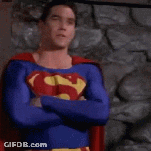 Man In Superman Costume Standing In Front Of Building GIF