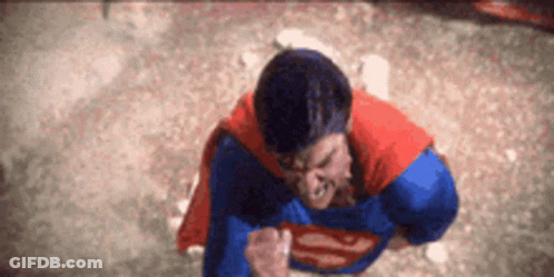 Man In Superman Costume Standing With Fist In Air GIF