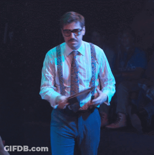 Man In Suspenders And Glasses Holding Paper GIF