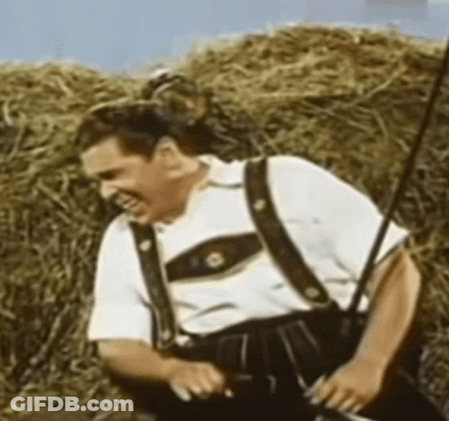Man In Suspenders Standing By Hay Bale GIF