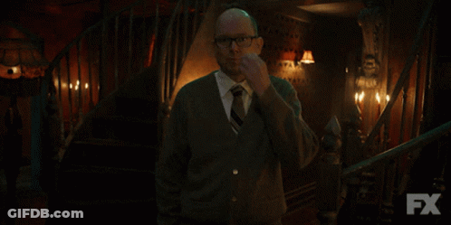 Man In Sweater And Tie In Front Of Stairs With FX GIF