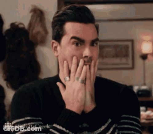 Man In Sweater Covering Mouth GIF