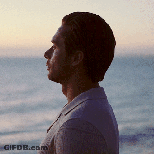 Man In Sweater Looking Out Over Ocean GIF