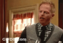 Man In Sweater Vest Holding Wine GIF