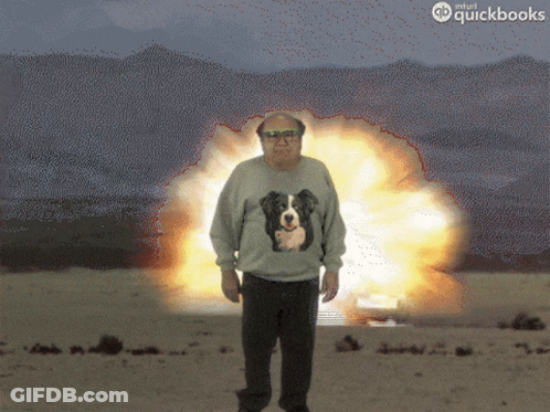 Man In Sweater With Dog Standing In Front Of Explosion GIF