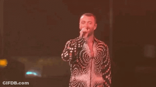 Man In Swirl Shirt Singing On Stage GIF