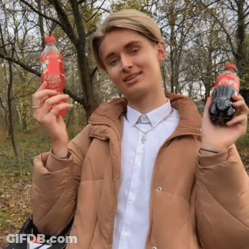 Man In Tan Jacket Holding Fanta And Coca Cola GIF