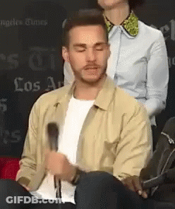 Man In Tan Jacket Sitting At Microphone GIF