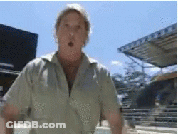 Man In Tan Shirt Surprised In Front Of Building GIF