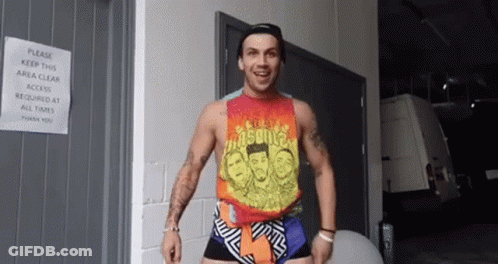 Man In Tank Top And Shorts Standing In Front Of Door GIF