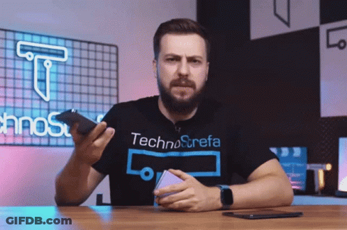 Man In Technostrefa T-Shirt Holding Phone GIF