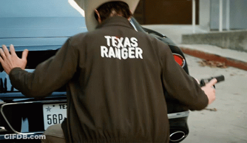 Man In Texas Ranger Jacket Holding Gun GIF