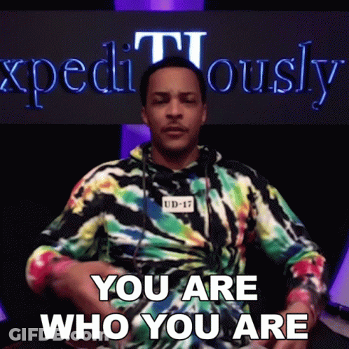 Man In Tie Dye Shirt Beside Expositiously Sign GIF