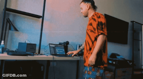 Man In Tie Dye Shirt Using Laptop GIF