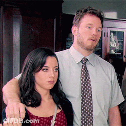 Man In Tie Next To Woman In Red Dress GIF