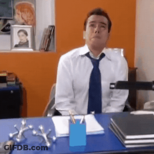 Man In Tie Sits At Desk GIF
