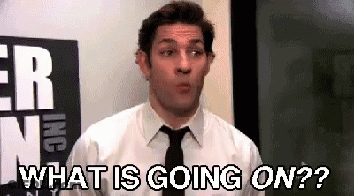 Man In Tie Standing In Front Of Sign Saying What Is Going On GIF
