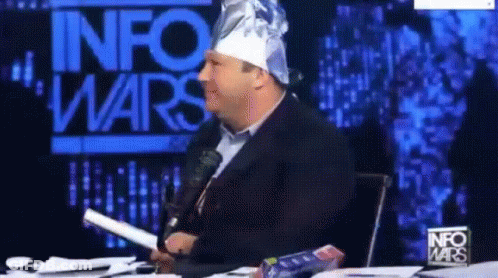 Man In Tin Foil Hat In Front Of InfoWars Sign GIF