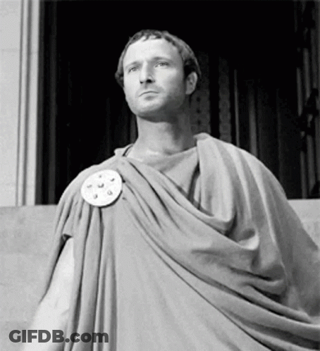Man In Toga Standing In Front Of Building GIF