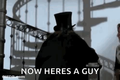 Man In Top Hat In Front Of Spiral Staircase GIF