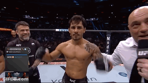 Man In Top Hat Riding Motorcycle Past Football Players GIF