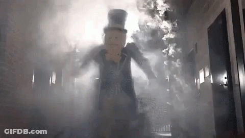 Man In Top Hat Walking Through Smoke Hallway GIF