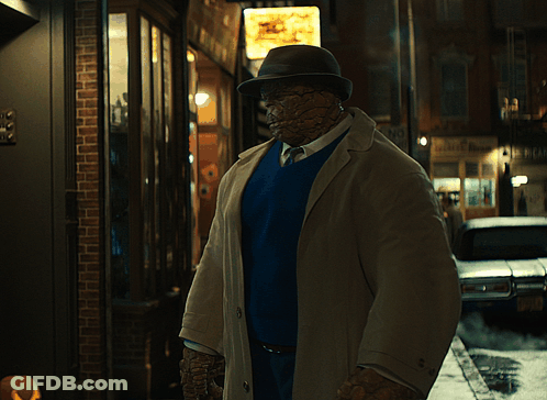 Man In Trench Coat And Hat In Front Of No Parking Sign GIF