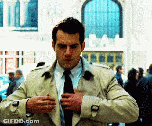 Man In Trench Coat And Tie In Front Of Cal Building GIF