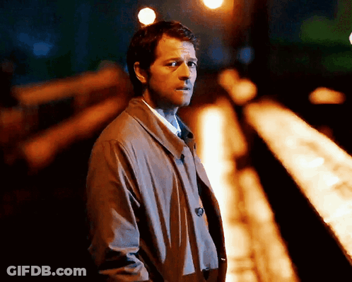 Man In Trench Coat And Tie On Train Track At Night GIF