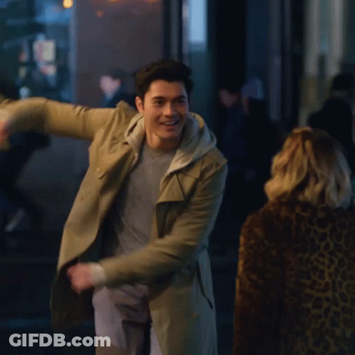 Man In Trench Coat Dancing In Front Of Woman GIF