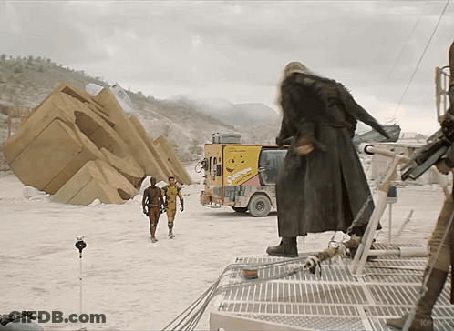 Man In Trench Coat In Front Of Snickers Truck GIF