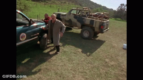 Man In Trench Coat Next To Sierra Truck GIF