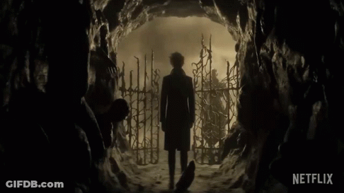 Man In Trench Coat Standing In Cave With Netflix Logo GIF