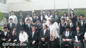 Man In Trench Coat Standing In Crowd GIF