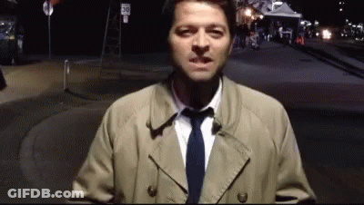 Man In Trench Coat Standing In Front Of Sign 30 GIF