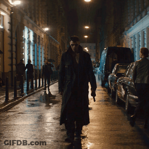 Man In Trench Coat Walking Down Dark Street GIF