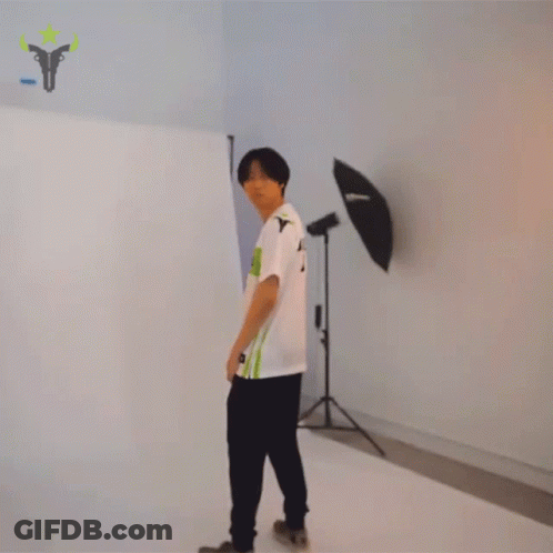 Man In TU Shirt Stands In Front Of Wall GIF