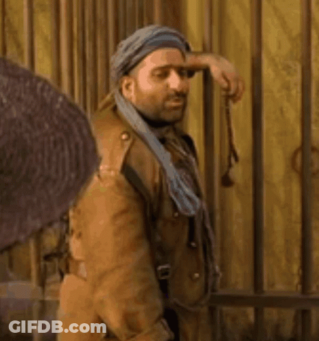 Man In Turban And Brown Coat Holding Gun GIF