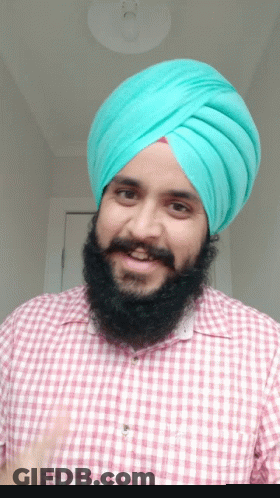 Man In Turban And Plaid Shirt Smiling GIF