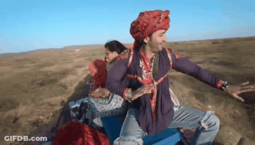Man In Turban And Purple Shirt Sitting On Blue Box GIF