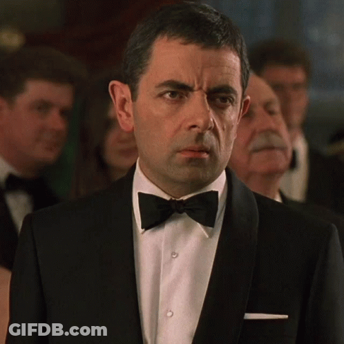 Man In Tuxedo And Bow Tie Looks At Camera GIF